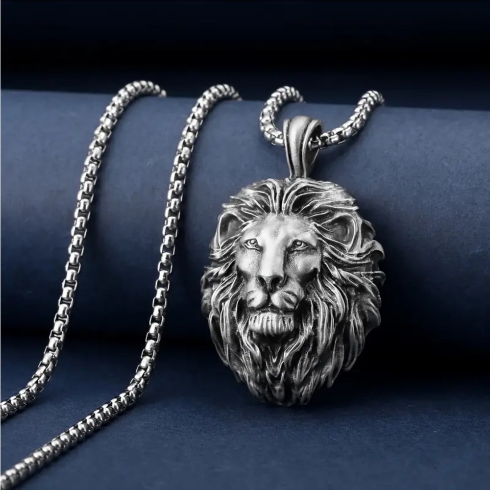 Lionhead silver tone necklace. 23.5” chain/weighted charm 2” by 1.2” NIP